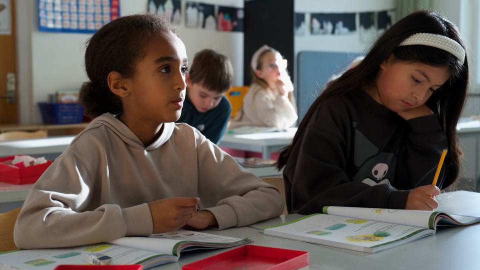 Barn i koncentration vid skolbänken.